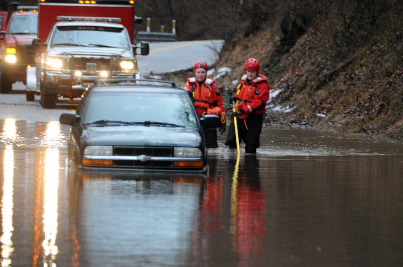 Wellsville water rescue Nyck Fair and Jake Albert stand with a woman rescued from her car that was driven into high waters on Detters Mill Road, Warrington Township on 
Thursday morning, 7:12 a.m., February 25.