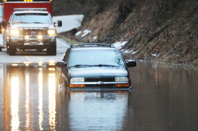 Wellsville water rescue Nyck Fair and Jake Albert stand with a woman rescued from her car that was driven into high waters on Detters Mill Road, Warrington Township on Thursday morning, 7:12 a.m., February 25.