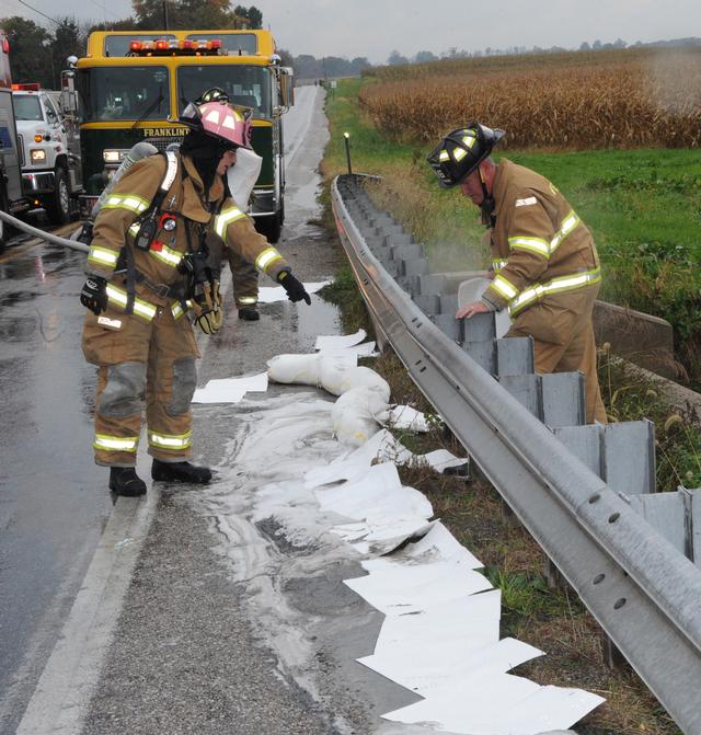 Stopping fluids from crash site on 10/15/12.  photo by Curt Werner.